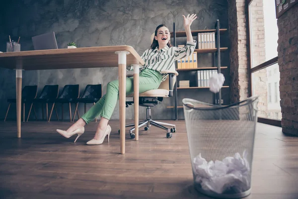 Pleine photo taille de travailleur joyeux positif marketing fille n'ont pas de travail se sentir amusant jeter du papier froissé dans la poubelle chaise assise dans le bureau loft moderne — Photo