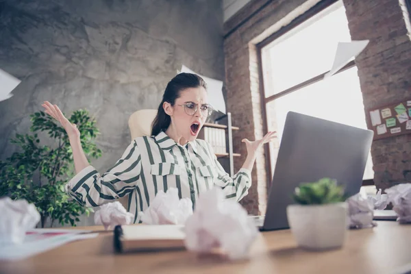 Furiosa chica indignada jefe uso portátil pantalla de aspecto sentir enojo sus collares se pierda puesta en marcha progreso estrategia proyecto plazo grito sentarse escritorio papel mosca en el lugar de trabajo estación de trabajo —  Fotos de Stock