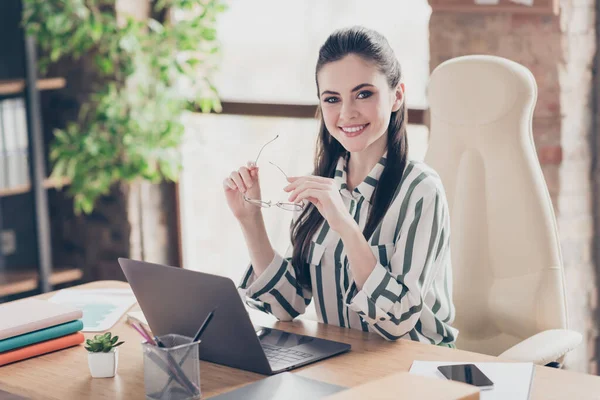 Retrato de positivo alegre chefe da empresa dono menina sentar mesa segurar seus óculos prontos bem-vindo seus parceiros de desenvolvimento startup na estação de trabalho moderna — Fotografia de Stock