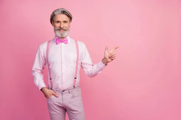 Portrait of his he nice attractive well-dressed imposing confident cheerful cheery grey-haired mature man showing copy empty blank space ad advert isolated over pink pastel color background — Stock Photo, Image