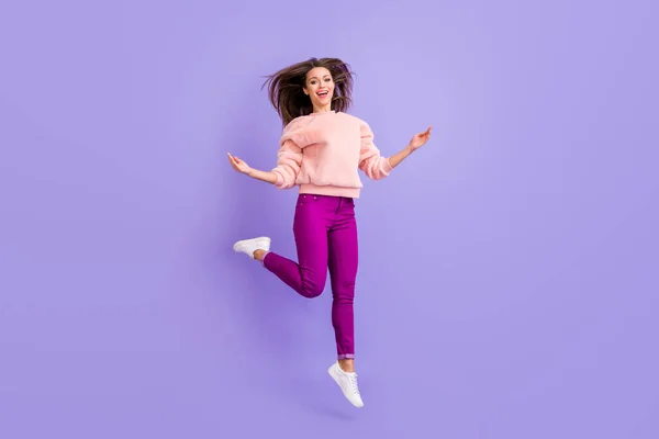 Full length profile photo of funny lady jumping high up rejoicing spend lovely time long hair flying air wear casual warm fluffy sweater pants shoes isolated purple color background — Stock Photo, Image