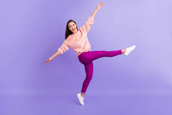 Foto de perfil de tamaño completo de la señora divertida regocijo pasar precioso tiempo bailando fiesta de la juventud levantar brazos pierna desgaste piel casual difusa suéter pantalones zapatillas aisladas color púrpura fondo —  Fotos de Stock