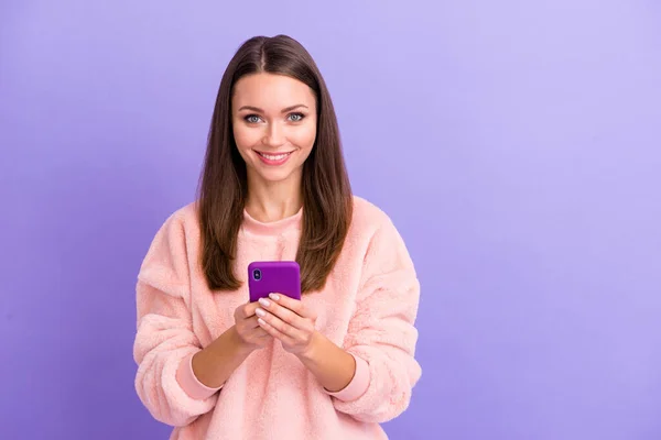 照片上漂亮的博客女士手牵着电话发短信给朋友聚会聚会聚会穿休闲装蓬松柔软的套头毛衣孤立的紫色背景 — 图库照片