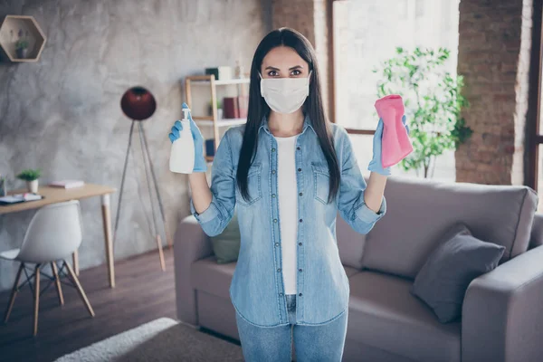 Portret van serieus keurig meisje meid demonstreren hoe ze zal voorkomen dat haar huis van corona virus infectie tonen ontsmettingsmiddel ontsmettende doek dragen jeans shirt in huis binnen — Stockfoto
