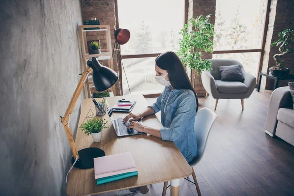 Foto von ziemlich verantwortungsbewusste Bürger Dame allein zu Hause bleiben Quarantäne Schreiben mit Notizbuch tragen schützen Anti-Virus-Maske Fernstudienarbeit abgelegene Wohnzimmer drinnen — Stockfoto