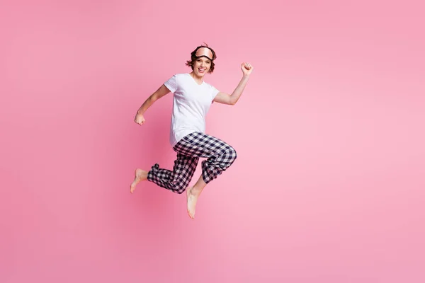 面白い女性ジャンプのフル長さの写真高までラッシュ低価格ショッピングマスク白いTシャツを着用睡眠服を変更していない再生パジャマパンツ裸足で隔離されたピンク色の背景 — ストック写真