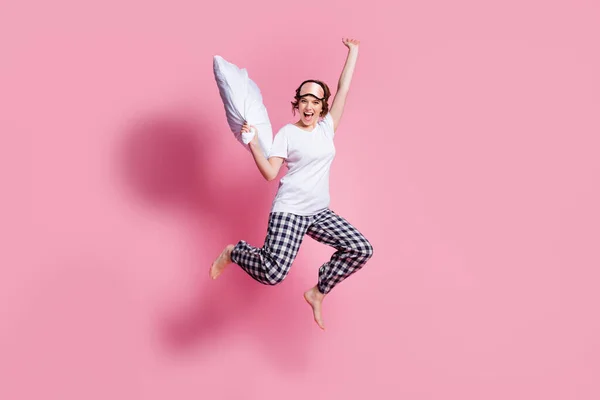 Foto de comprimento total de senhora alegre engraçado saltar alto para cima travesseiro luta regozijando partido usar máscara de sono branco t-shirt xadrez calças de pijama descalço isolado cor rosa fundo — Fotografia de Stock