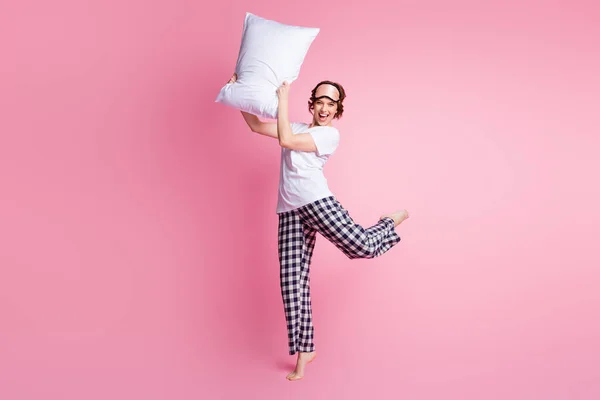 面白い女性のフルサイズ写真を上げる枕戦い良い気分眠りの女の子夜の着用睡眠マスク白いTシャツチェックパジャマパンツ裸足で隔離されたピンク色の背景 — ストック写真
