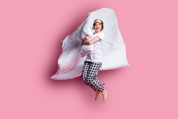 Full Size Foto von netten Dame springen hohe Umarmung Kissen Decke Flug Schlummer Party Mädchen Nacht tragen Schlafmaske weißes T-Shirt karierte Pyjamahose barfuß isoliert rosa Farbe Hintergrund — Stockfoto