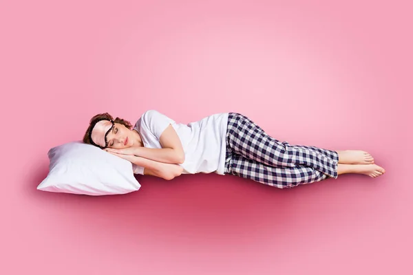 Helkroppsfoto av vacker dam njuta av lördag morgon tupplur liggande säng kudde händer under huvudet bära mask vit t-shirt rutig pyjamas byxor barfota isolerad rosa färg bakgrund — Stockfoto