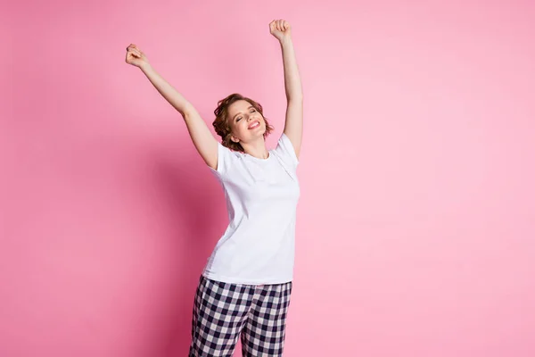 Φωτογραφία της όμορφης κυρίας υπνηλία πρωί μάτια κλειστά απολαύσετε το Σάββατο σηκώστε τα χέρια μέχρι τέντωμα φορούν λευκό t-shirt καρό παντελόνι πυτζάμα απομονωμένο ροζ χρώμα φόντο — Φωτογραφία Αρχείου