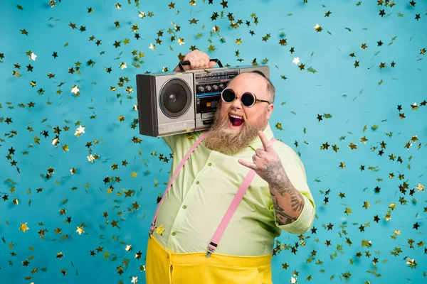 Portrét jeho on pěkný atraktivní veselý veselý funky cool šílený vousatý chlap nesoucí boombox ukazující rohu znamení izolované přes jasný živý lesk pulzující modrá barva pozadí — Stock fotografie