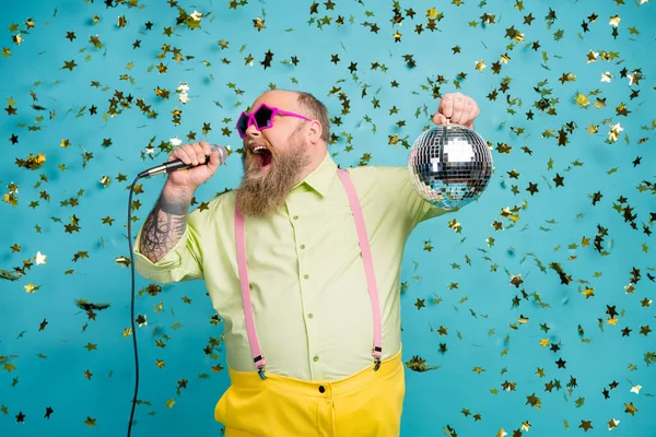 Portrét jeho hezký atraktivní veselý vousatý zralý chlap drží v ruce diskotéka míč s zábavou zpěv karaoke izolované přes jasný živý lesk pulzující modrá barva pozadí — Stock fotografie