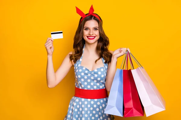 Ritratto di positivo allegro centro commerciale cliente ragazza comprare molti borse pagare con carta di credito tenere usura blu vintage vestiti rosso fascia isolata su luminoso brillantezza colore sfondo — Foto Stock