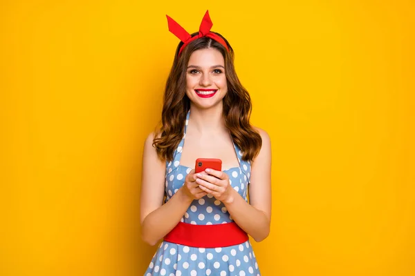 Πορτρέτο του χαριτωμένο γλυκό όμορφο κορίτσι χρησιμοποιούν smartphone ψύξη θέσεις blogging φορούν vintage στυλ polka-dot headband μπλε στολή απομονώνονται σε φωτεινό χρώμα λάμψη φόντο — Φωτογραφία Αρχείου