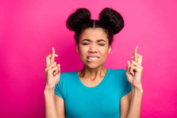 Närbild foto av vacker mörk hud dam två bullar frisyr korsning fingrar slutna frågar framgångsrik passerar examen bära blå casual t-shirt isolerad levande rosa färg bakgrund — Stockfoto