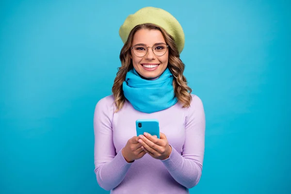 Portré a pozitív vidám lány használata okostelefon élvezni megjegyzést szociális háló utáni hűtés viselni jó megjelenés jumper elszigetelt felett kék színű háttér — Stock Fotó