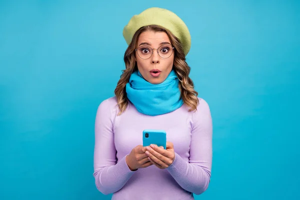 Retrato de chica asombrada uso de teléfono celular leer información de redes sociales impresionado grito wow omg desgaste jersey de moda aislado sobre fondo de color azul — Foto de Stock