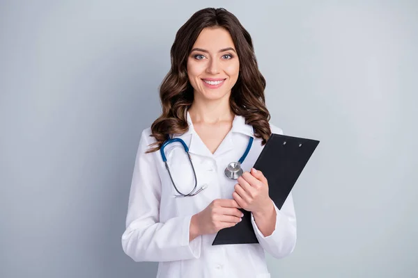 Фото красивого веселого професійного лікаря-терапевта внутрішньої жінки, що тримає паперові папери медичні рецепти, одягнені в білий лабораторний стетоскоп ізольований сірий кольоровий фон — стокове фото