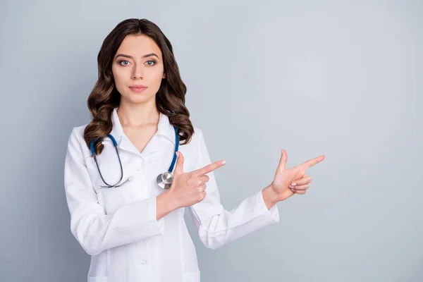 Çekici aile doktoru deneyimli bayan viroloji kliniği doğrudan parmakları boş uzay göstergesi salgın kuralları dezenfeksiyonu laboratuvar önlüğü ve izole edilmiş gri arkaplan giyin — Stok fotoğraf