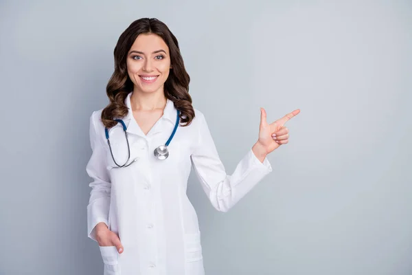 Regularnie myć ręce. Photo of beautiful family doc lady assistant virology clinic direct finger empty space show banner rules safety wear lab coat isolated grey color background — Zdjęcie stockowe