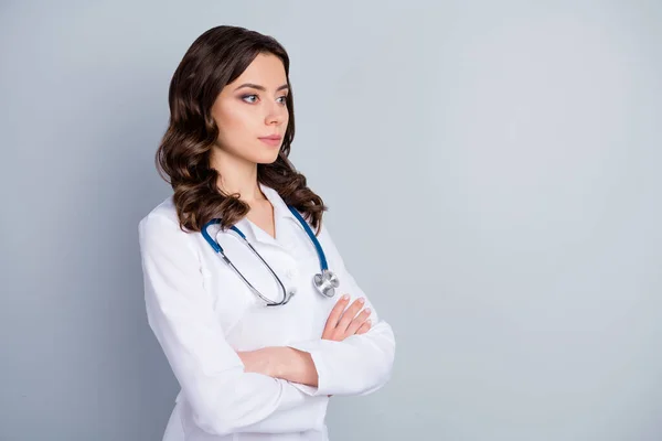 Foto de perfil de atractiva familia doc señora pacientes consulta no sonriente virología clínica brazos cruzados mirar espacio vacío usar bata de laboratorio estetoscopio aislado color gris fondo — Foto de Stock