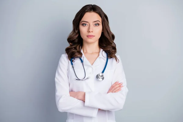 Φωτογραφία από ελκυστική ιατρός ιατρός κυρία ασθενείς διαβούλευση δεν χαμογελά αξιόπιστο πρόσωπο ιολογία χέρια σταυρωμένα φορούν λευκό εργαστηριακή ποδιά στηθοσκόπιο απομονωμένο γκρι χρώμα φόντο — Φωτογραφία Αρχείου