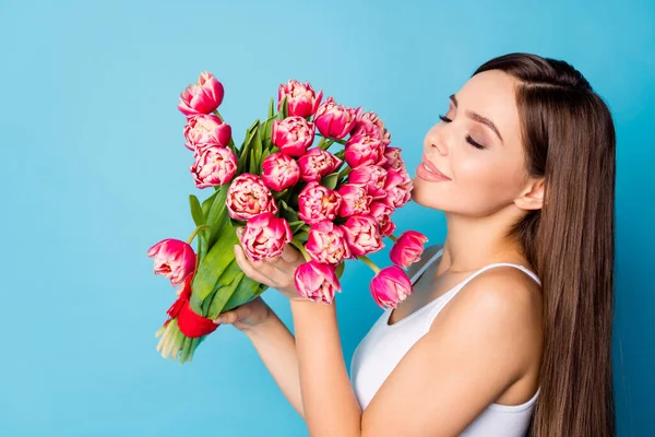 Foto del lado del perfil de la encantadora chica linda olor montón de tulipanes disfrutar 14-febrero 8-marzo celebración llevar camiseta aislada sobre fondo de color azul — Foto de Stock