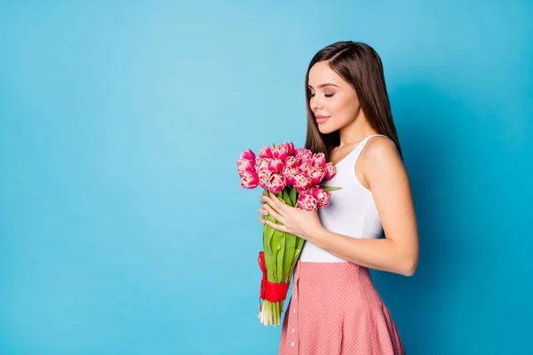 Profiel side photo of charming lovely cute girl smell fresh natural 8-march gift tulpen dragen tank-top geïsoleerd over blauwe kleur achtergrond — Stockfoto