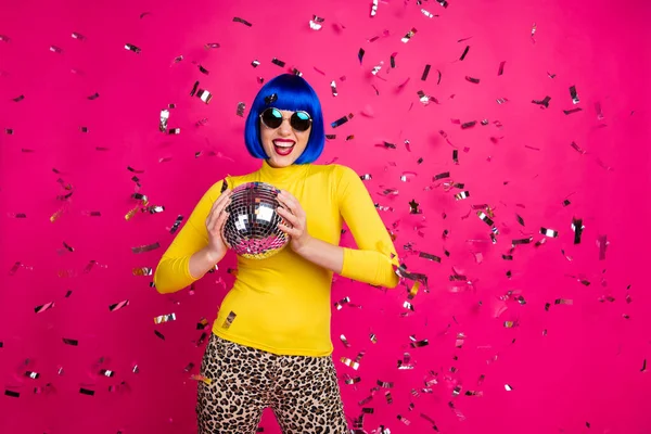 Photo of pretty funny lady party nightclub hold disco ball dancing queen confetti fall wear specs yellow turtleneck blue short wig leopard pants isolated bright pink color background — Stock Photo, Image