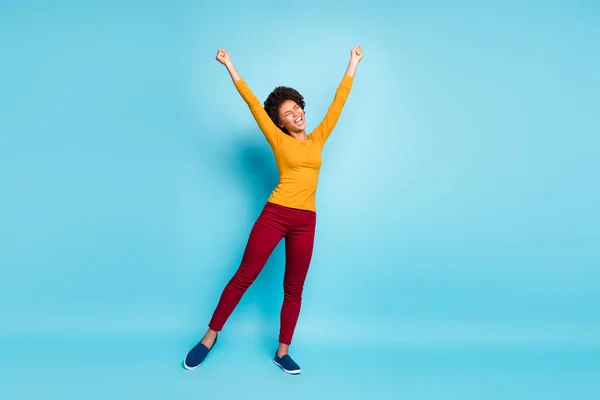 Heyecanlı afro-amerikalı kızın tüm vücudu mutlu sonbaharda dinlenmenin keyfini çıkarın tatilde yumruk kaldırın mavi arka planda izole edilmiş kırmızı pantolon giyin — Stok fotoğraf