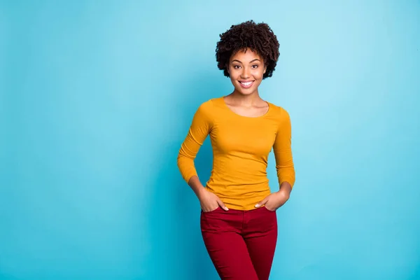 Retrato de imponente chica afroamericana franca encantadora disfrutar de los fines de semana de otoño tiempo libre poner bolsillos de mano se ven bien desgaste traje de jersey moderno aislado sobre fondo de color azul — Foto de Stock