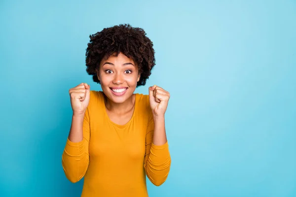 Retrato de positivo alegre animado afro menina americana esperar por sua loteria incrível ganhar presente de aniversário presente levantar punhos usar camisola estilo casual isolado sobre fundo de cor azul — Fotografia de Stock