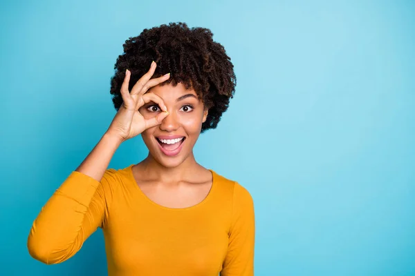 Retrato de animado surpreso afro-americano menina mostrar sinal ok fazer binóculos ver olhar impressionado grito wow omg desgaste elegante camisola da moda isolado sobre fundo de cor azul — Fotografia de Stock