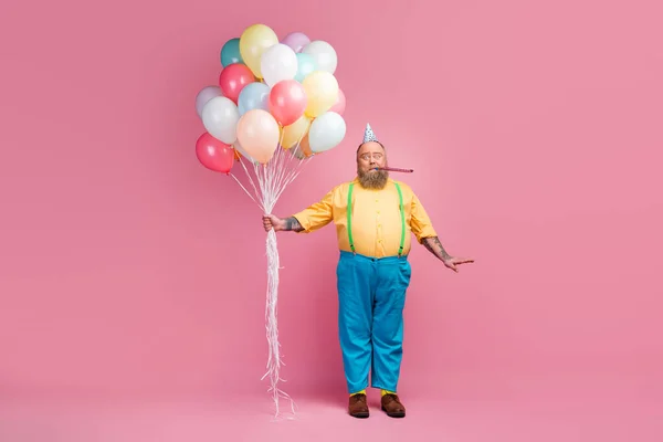 Uzun boylu, sakallı, hoş bir adamın el ele tutuşup tek başına ıslık çalarak eğlendiğini pembe pastel arka planda yalnız başına. — Stok fotoğraf