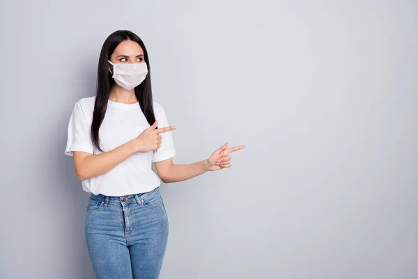 Portrait of confident girl promoter point index finger copyspace look demonstrate covid-19 protection wear t-shirt denim jeans medical mask isolated gray color background — Stock Photo, Image