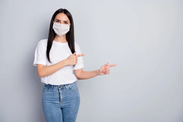 Εμπιστοσύνη κορίτσι υποστηρικτής στην ιατρική μάσκα σημείο δείκτη copyspace αποδείξει coronavirus πληροφορίες παρουσιάζουν προστασία της ασφάλειας φορούν λευκό t-shirt τζιν απομονωμένο γκρι χρώμα φόντο — Φωτογραφία Αρχείου