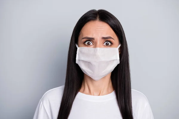 Portret van geschokt doodsbang meisje horen verschrikkelijke corona virus epidemie verspreiden nieuws dragen medisch masker wit t-shirt geïsoleerd over grijze kleur achtergrond — Stockfoto