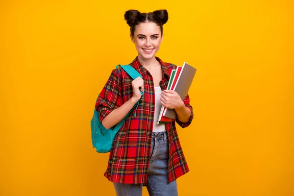 Photo of attractive student lady hold copybooks 1 september first study day blue rucksack on shoulder good mood wear casual plaid shirt jeans isolated yellow color background — Stock Photo, Image