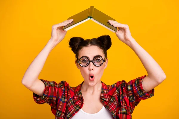 Foto de señora bastante loca dos bollos sostienen libro abierto por encima de la cabeza no quieren leer la tarea sin preocupaciones estudiante alumno desgaste geek especificaciones casual camisa a cuadros aislado color amarillo fondo —  Fotos de Stock