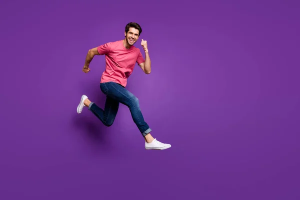 Full size foto profilo di bel ragazzo attraente salto in alto correre centro commerciale prezzi di vendita indossare casual rosa t-shirt jeans calzature isolato colore viola sfondo — Foto Stock