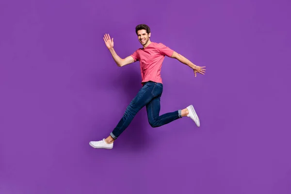 Фотография всего тела жизнерадостного энтузиаста, который прыгает, когда его подруга машет рукой, говоря, что он носит ботинки в хорошем молодежном стиле, изолированные на светлом цветовом фоне — стоковое фото