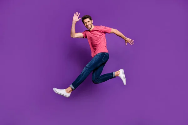 Полноразмерная фотография веселого взволнованного энтузиаста, прыгающего, когда его друг машет рукой, говоря, что он носит красивый наряд, изолированный на ярком цветовом фоне — стоковое фото