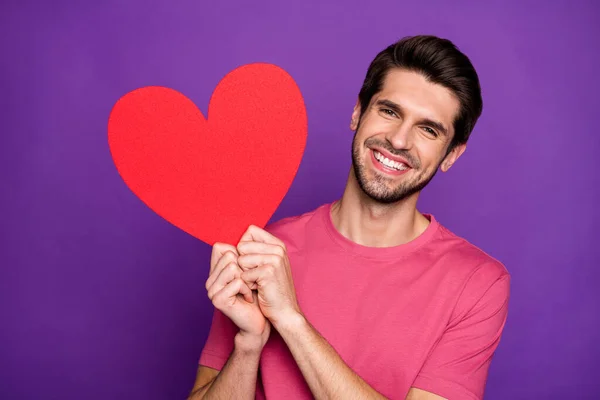 Portrait of cheerful candid guy hold big red paper card heart he get on 14-february celebration feel grateful wear style stylish trendy clothes isolated over bright color background — Stock Photo, Image