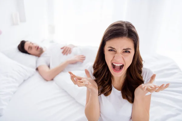 Φωτογραφία από δύο άτομα έξαλλη οργή κορίτσι δεν μπορεί να κοιμηθεί ο σύζυγός της ροχαλίζουν δυνατά κάνουν ξύπνιοι ουρλιάζουν θυμωμένος φωνάζουν φορούν λευκό t-shirt στο σπίτι σε εσωτερικούς χώρους — Φωτογραφία Αρχείου