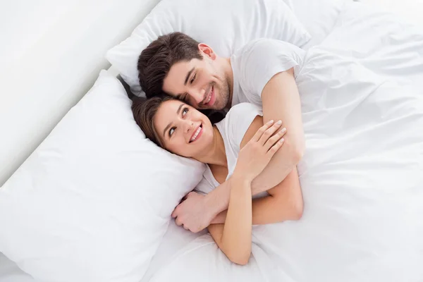 Sudut tinggi di atas melihat foto suami wanita cantik pasangan berbaring seprai yang nyaman selimut putih pagi memeluk tangan menggembirakan melihat mata memakai ruang piyama di dalam ruangan — Stok Foto