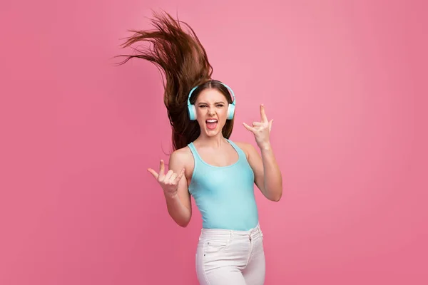 Ritratto di lei lei bella attraente allegra allegra ragazza dai capelli dritti divertirsi mostrando corno simbolo ascolto canzone capelli setosi volare isolato su sfondo rosa pastello — Foto Stock