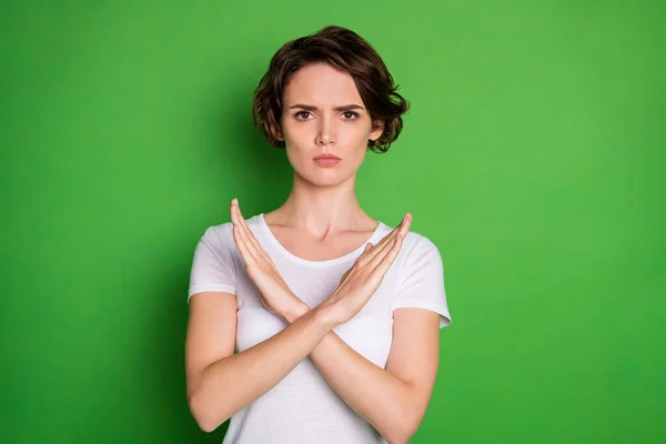 Photo of beautiful serious lady trzymać się za ręce skrzyżowane pokazując negatywną reakcję powiedzieć nie do zabijania zwierząt koncepcja wolontariuszy nosić biały t-shirt odizolowany zielony kolor tła — Zdjęcie stockowe