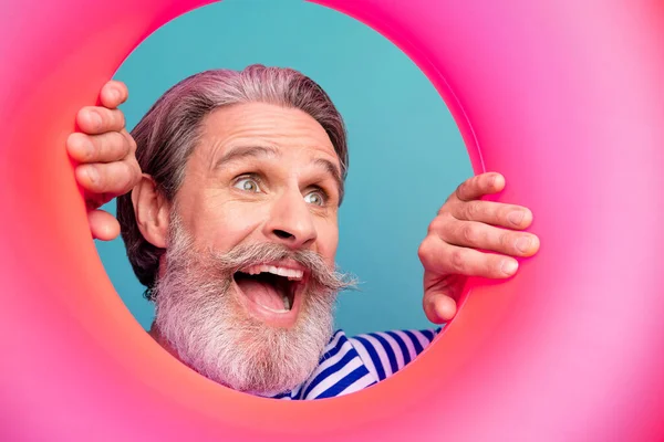 Closeup photo of excited interested funny aged guy seaman open mouth tourist look inside pink rubber float lifebuoy wear striped sailor shirt isolated teal color background — Stock Photo, Image