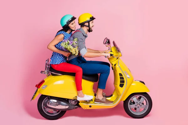 Full längd profil sida foto av positiva glada cyklister förare ryttare två personer kör motorcykel njuta resa kvinna grepp bära vilda blommor bukett isolerad pastell färg bakgrund — Stockfoto